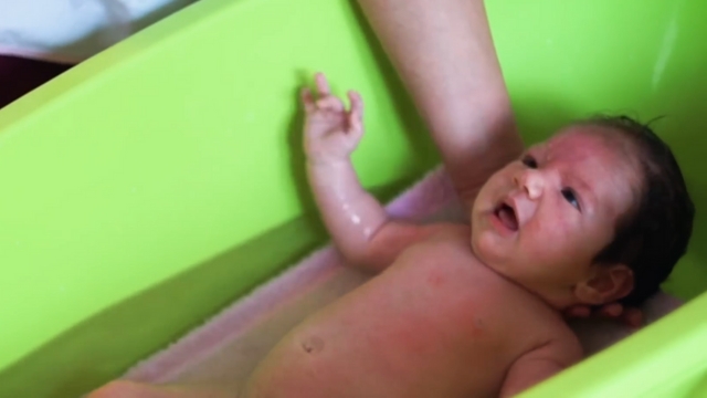 Osoba kupa dete sa ekcemom u kadici