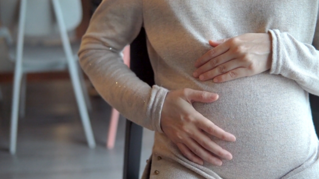 Trudnica drži ruke na stomaku